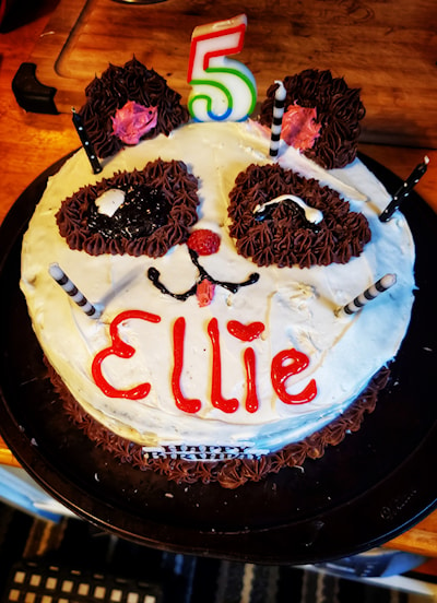 "A panda cake with one winking eye and sticking it's tongue out!"