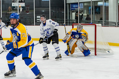 Cougars forward Dylan Winsor screens Lake State goaltender during ACHA action!