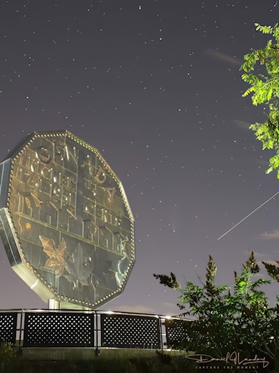 Sudbury's Big Nickel stands proudly under the night sky,  accompanied by the Big Dipper,  the ISS and the comet Neowise 