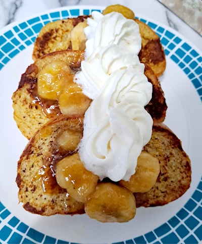 French Toast toppeed with caramelized bananas and whip cream.