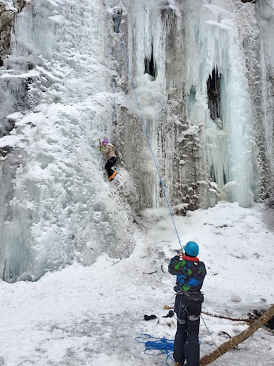 2 young guys climbing and belaying